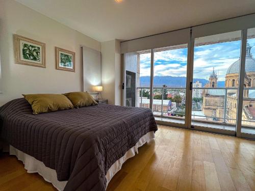 1 dormitorio con cama grande y ventana grande en Plaza suite La Rioja en La Rioja