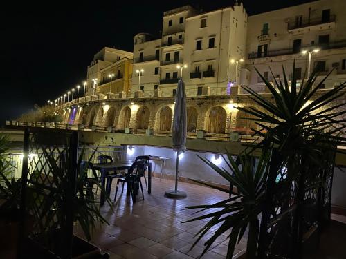 a patio with a table and umbrella in front of a building at Terrazza mare home in Rodi Garganico
