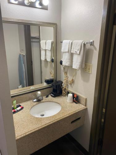 y baño con lavabo, espejo y toallas. en Days Inn by Wyndham Perryville, en Perryville