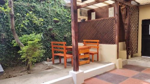 Duas cadeiras de madeira e uma mesa num pátio em AZURA HOTEL BOUTIQUE em Cobán
