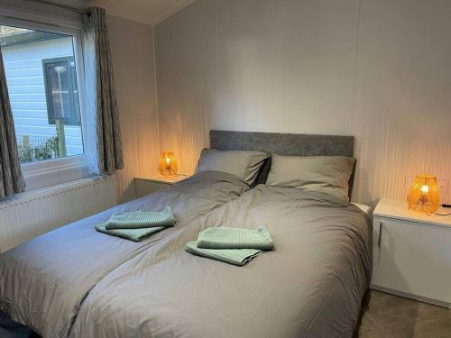 ein Schlafzimmer mit einem Bett mit zwei Kissen darauf in der Unterkunft Luxe chalet (gloednieuw!) in Hoenderloo in Hoenderloo