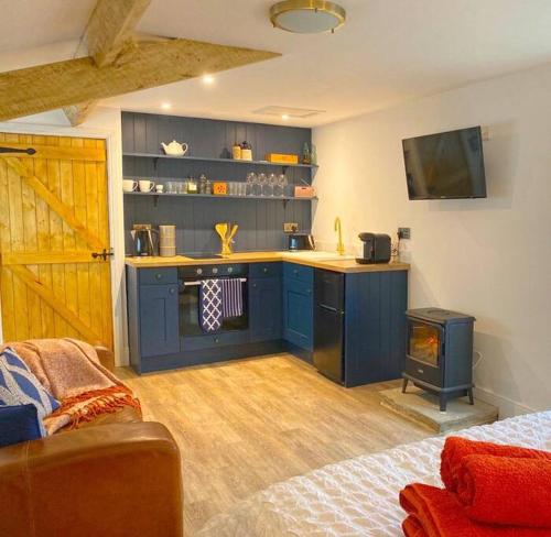 a kitchen with blue cabinets and a stove in a room at The Little House in Cotherstone