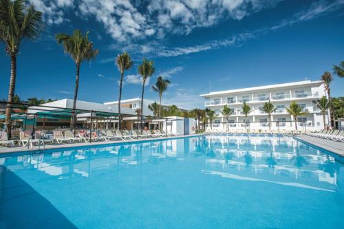 a large swimming pool in front of a hotel at Riu Playacar - All Inclusive in Playa del Carmen
