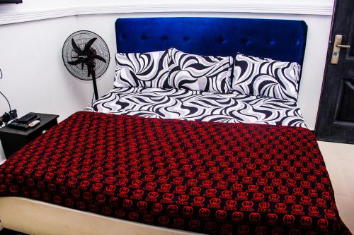 a bed with a red and black blanket on it at Unique 1BEDROOM Shortlet Stadium Rd with 24hrs light-FREE WIFI -N58,000 in Port Harcourt