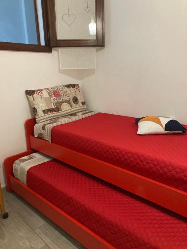 a bedroom with a red bed and a red mattress at al Sulcis 35 in Teulada