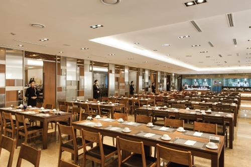 Migliore Hotel Seoul Myeongdong في سول: غرفة طعام كبيرة مع طاولات وأشخاص في الخلفية