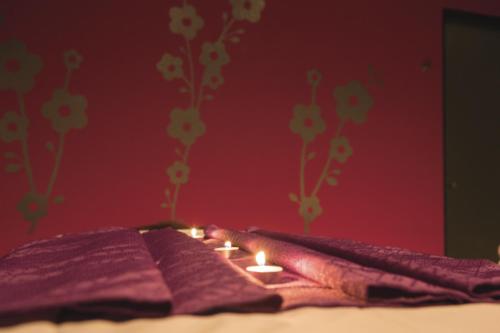 an open book with lit candles on a bed at Riu Playacar - All Inclusive in Playa del Carmen