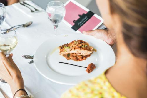 a woman sitting at a table with a plate of food at Riu Playacar - All Inclusive in Playa del Carmen