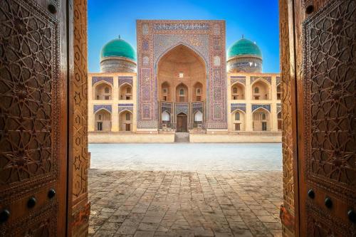 a view of a mosque through an open door at LION Guest House in Bukhara