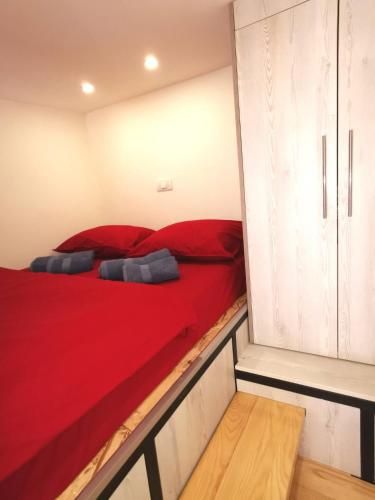 a bedroom with a red bed and cabinets at Dunja Apartmans in Belgrade