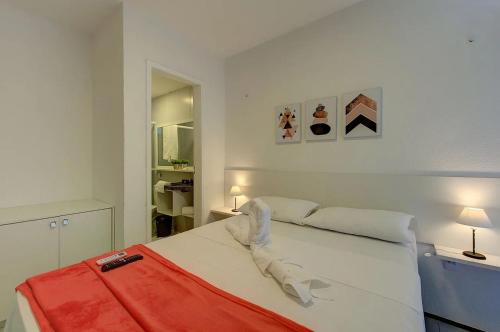 um quarto com uma cama branca com um cobertor vermelho em Beach Townhouses #C8 - Aconchego por Carpediem em Aquiraz