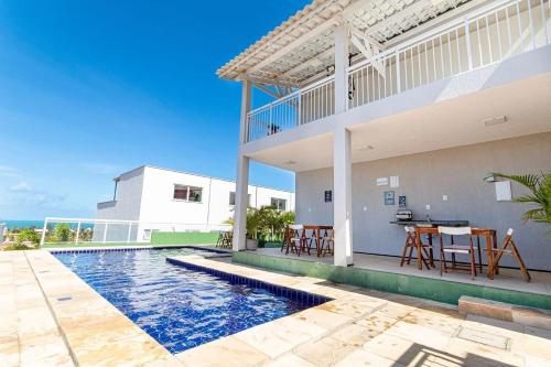 una casa con piscina di fronte a una casa di Beach Townhouses #C8 - Aconchego por Carpediem ad Aquiraz