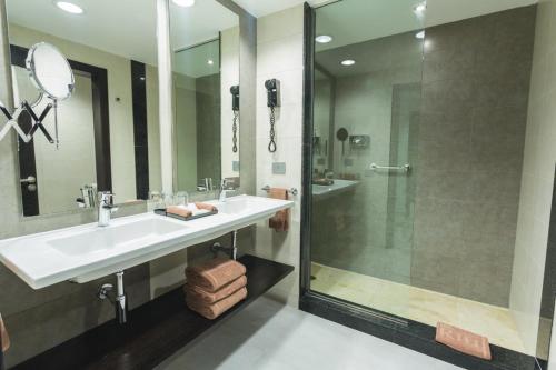 a bathroom with a sink and a shower at Riu Playacar - All Inclusive in Playa del Carmen