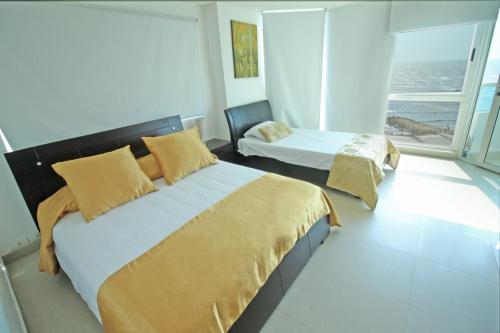 a bedroom with two beds and a large window at Apartamento torres del lago in Cartagena de Indias