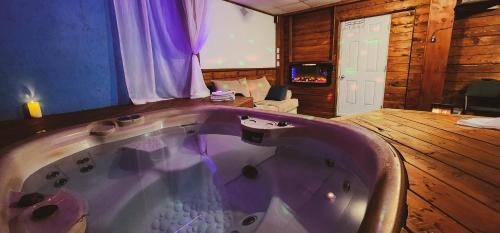 a large bath tub in a room with a living room at Petit studio très intime, avec spa intérieur au coeur de Shawinigan in Shawinigan