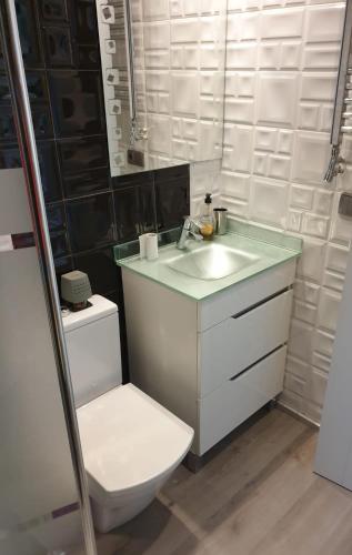 a bathroom with a white sink and a toilet at Sitges Oasis in Sitges