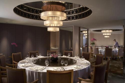 a dining room with a long table with chairs and a chandelier at Shangri-La Far Eastern Tainan in Tainan
