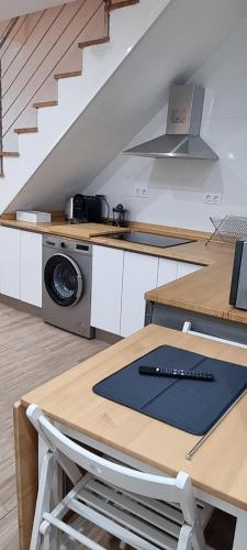 a kitchen with a counter with a stove and a sink at Apartamentos Les Texuques II in Nueva de Llanes