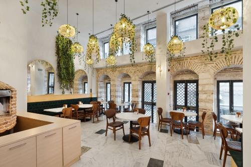 une salle à manger avec tables, chaises et lustres dans l'établissement Pera Rasso Hotel, à Istanbul