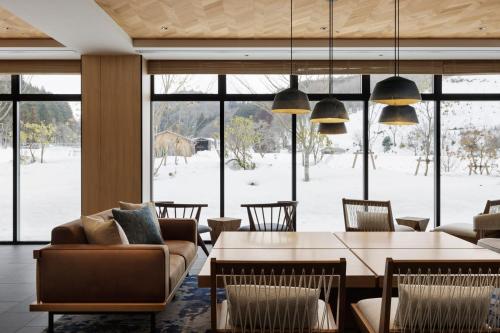 a living room with a table and chairs and a large window at Fairfield by Marriott Okayama Hiruzen Highland in Maniwa