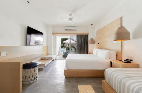 a hotel room with two beds and a desk at Bahia Hotel & Beach House in Cabo San Lucas