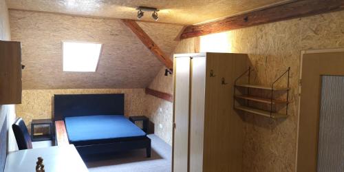 Un pequeño dormitorio con una cama azul en una habitación en Pension Dingolshausen, en Dingolshausen