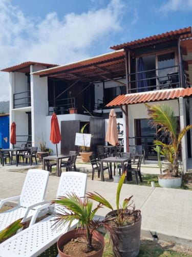 eine Terrasse mit Stühlen und Tischen vor einem Haus in der Unterkunft Casa Bajo Congo in Cacique