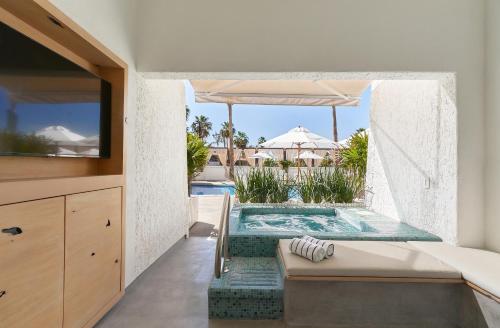 a bedroom with a swimming pool in the middle of a house at Bahia Hotel & Beach House in Cabo San Lucas