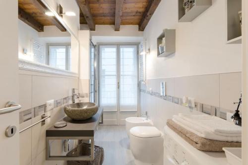 un bagno bianco con lavandino e WC di Antico Loft Como a Como