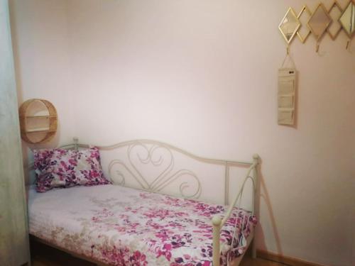 Schlafzimmer mit einem Bett mit einer rosa und weißen Bettdecke in der Unterkunft Cosy home Lalëz Durrës in Mullini i Danit