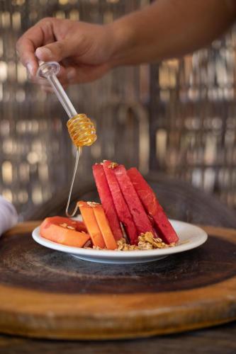 een persoon met een spatel over een bord voedsel bij Pousada Paraiso dos Ventos Preá in Prea