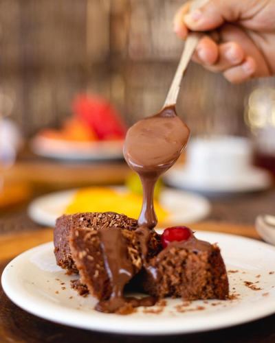 een persoon die een stuk chocoladetaart eet met een lepel bij Pousada Paraiso dos Ventos Preá in Prea