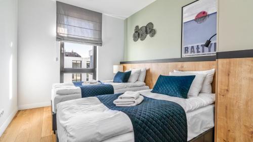 twee bedden in een kamer met blauw en wit bij Okrzei DeLUX - Comfy Apartments in Sopot