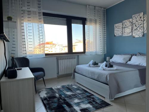 Casa Manthone - Intero Appartamento في بيسكارا: غرفة نوم زرقاء مع سرير وكرسي
