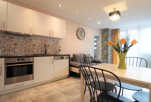 a kitchen and dining room with a table and chairs at KGHN Apartments Wyszyńskiego in Szczecin