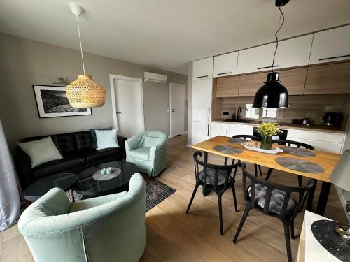 eine Küche und ein Wohnzimmer mit einem Tisch und Stühlen in der Unterkunft Apartament Pod Ojcowem in Skała