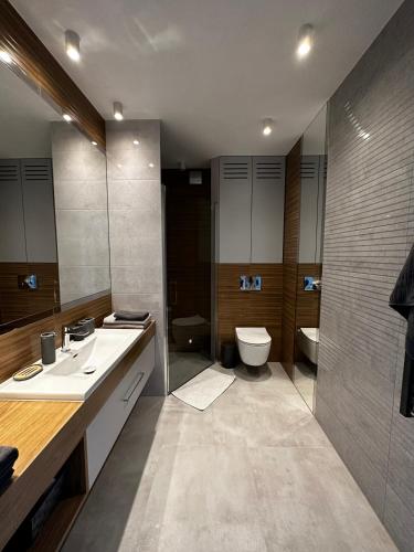 a bathroom with two sinks and a toilet and a shower at Apartament Pod Ojcowem in Skała