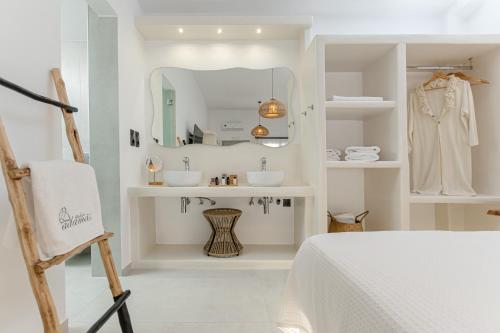 a white bathroom with two sinks and a mirror at Adamas Studios in Naxos Chora