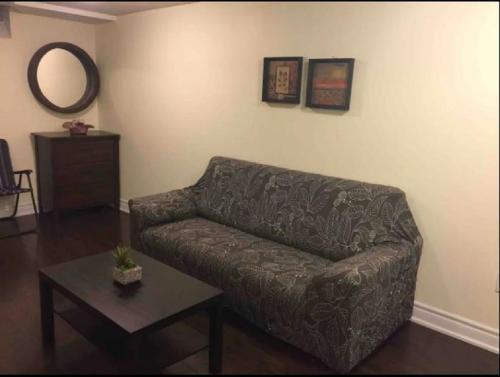 a living room with a couch and a table at Cozy & Spacious Suite with Private Bathroom near Toronto Airport ! in Mississauga