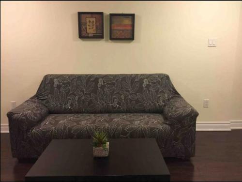 a couch in a living room with a table at Cozy & Spacious Suite with Private Bathroom near Toronto Airport ! in Mississauga