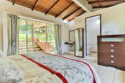 a bedroom with a large bed and a bathroom at Casa MALI con alberca. in Malinalco