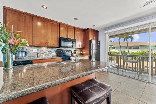 a kitchen with wooden cabinets and a counter top at Wailana Sands 206 in Kihei