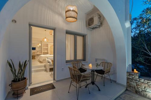 a patio with a table and chairs and a bedroom at Adamas Studios in Naxos Chora