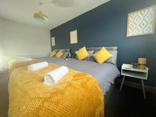 1 dormitorio con 2 camas y paredes amarillas y azules en Stylish 2 bed apartment., en Birmingham