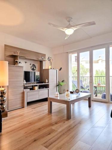- un salon avec un ventilateur de plafond et une table dans l'établissement Eden Cassis - Centre Ville 2 chbres - Wifi - Clim, à Cassis