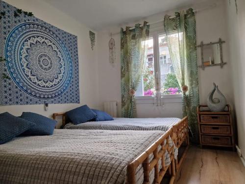 une chambre avec deux lits et une fenêtre dans l'établissement Eden Cassis - Centre Ville 2 chbres - Wifi - Clim, à Cassis