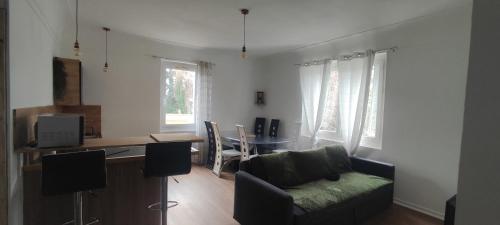 a living room with a couch and a table at appart de charme a 2 pas du centre de Montbrison in Montbrison