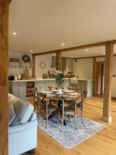 a kitchen and dining room with a table and chairs at Hideaway Barn Coltishall in Coltishall