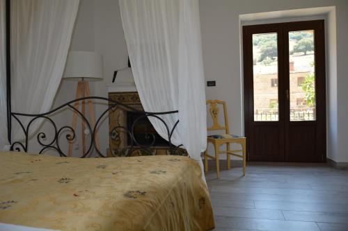 1 dormitorio con 1 cama y puerta con ventana en Antico Borgo Buonanotte, en San Mauro Castelverde