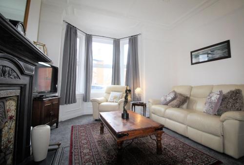 uma sala de estar com um sofá e uma mesa de centro em Newcastle - Heaton - Great Customer Feedback - 5 Large Bedrooms - Period Property - Refurbished Throughout em Newcastle upon Tyne
